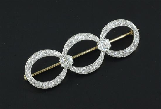 A gold, platinum and diamond triple loop brooch, 2.25in.